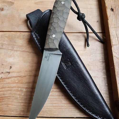 Slim and sharp utility knife in O1 carbon and linen micarta with black leather sheath. Slim and sharp utility knife in O1 carbon and linen micarta with black leather sheath.